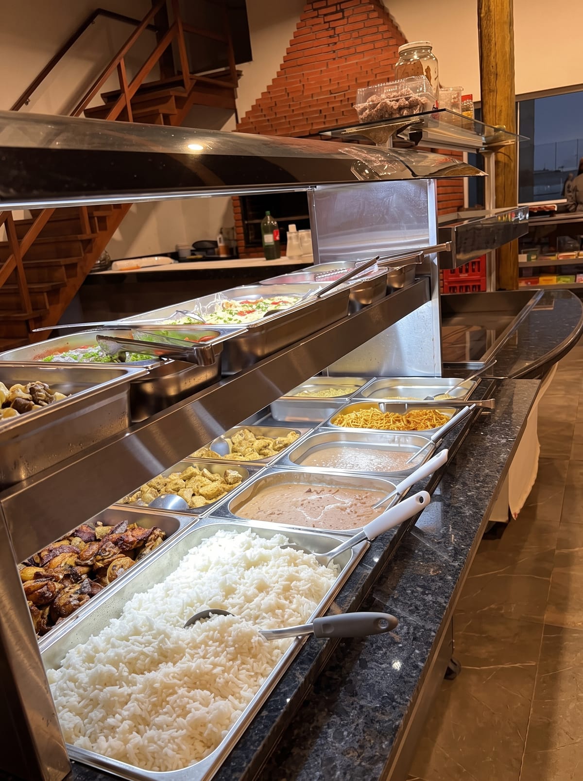 Buffet de refeições com arroz, feijão, carnes e acompanhamentos