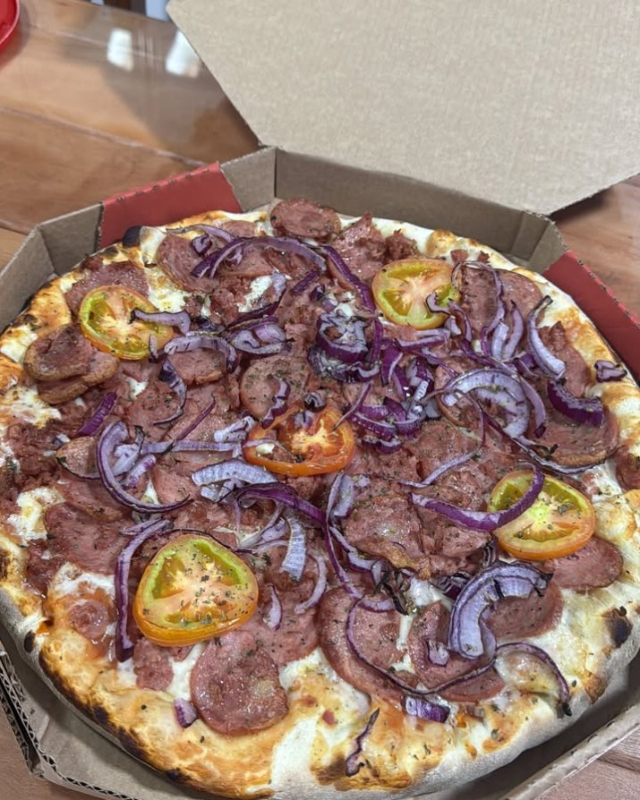 Pizza de calabresa com cebola roxa e tomate